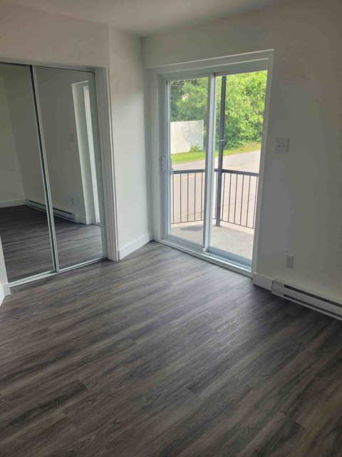 a living room with a hard wood floor and sliding glass doors