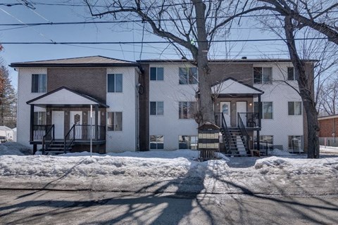 a row of houses with snow in front of them
