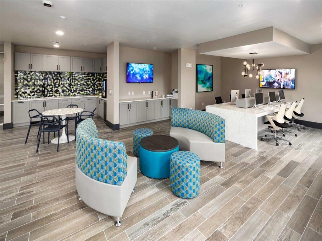 a lobby with chairs and a table and a tv