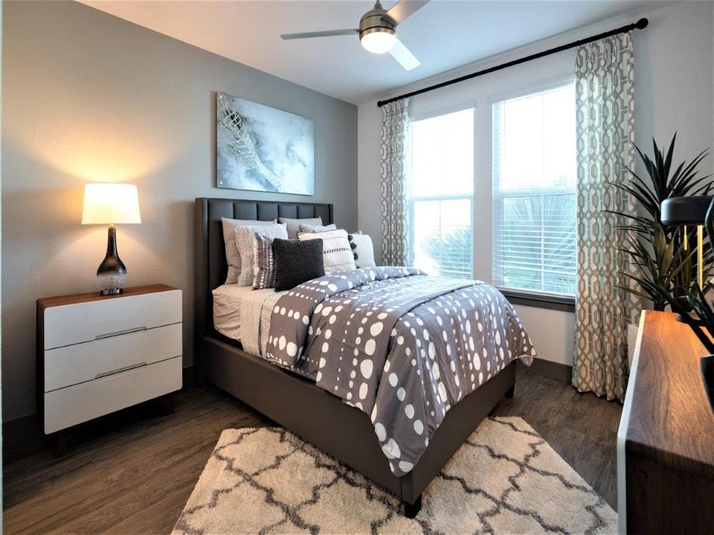 A bedroom with a bed, nightstand, and a ceiling fan.