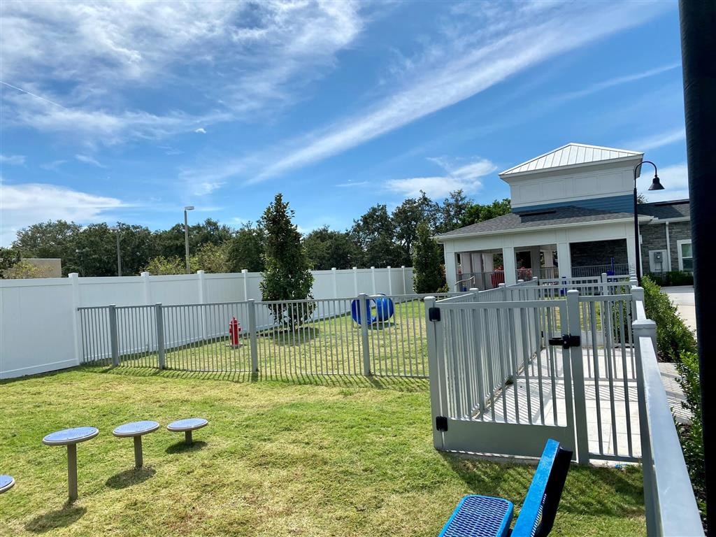a small yard with a fence and a house with a playground