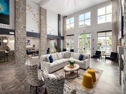 a living room with couches and chairs and large windows