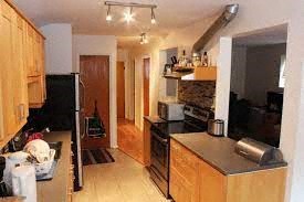 A kitchen with wooden cabinets and a black refrigerator.