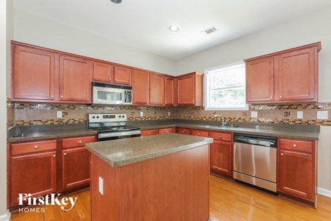 a kitchen with wooden cabinets and stainless steel appliances and granite counter tops