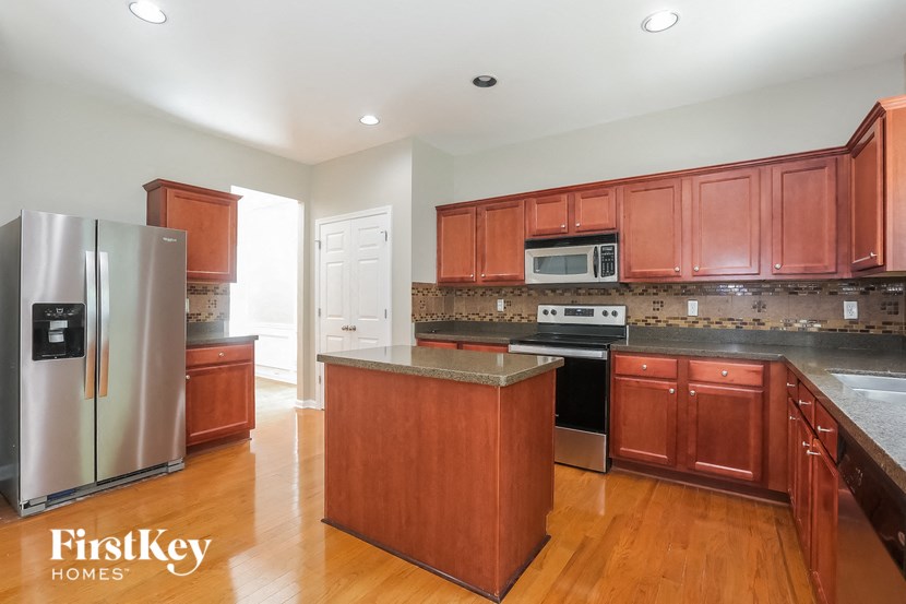 a kitchen with cherry wood cabinets and stainless steel appliances