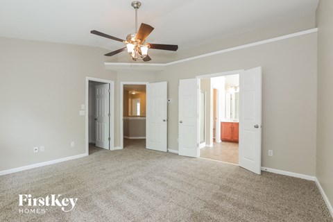 a living room with carpet and a ceiling fan