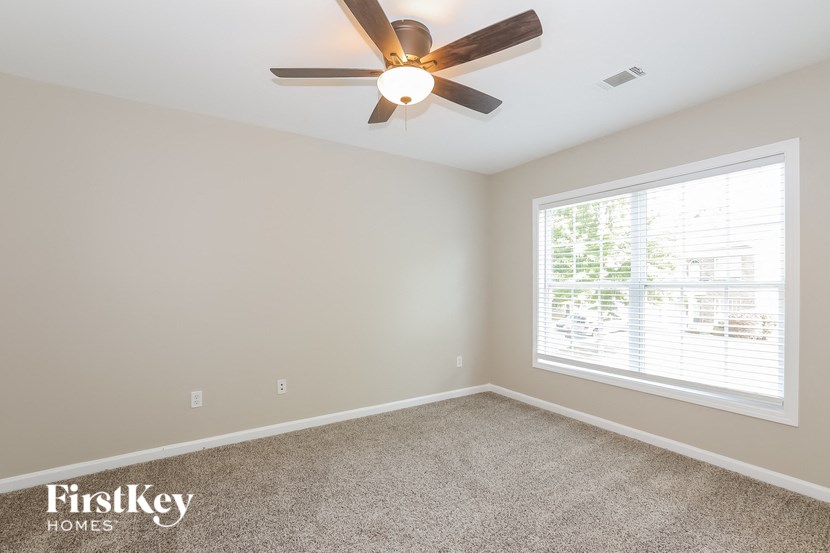 a bedroom with a ceiling fan and a window