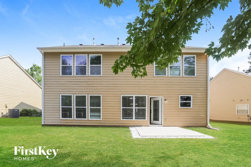 a yellow house with a yard and a tree