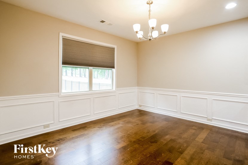 a empty dining room with wood floors and a window