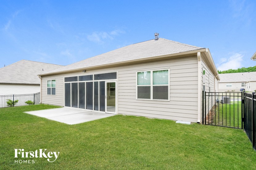a white house with a yard and a black fence