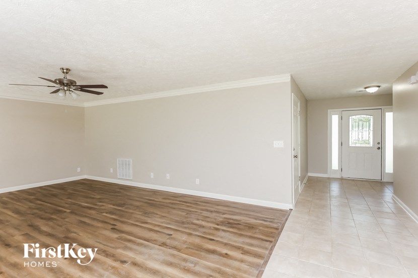 an empty living room with a ceiling fan