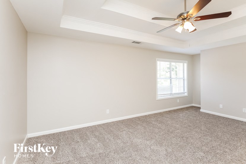 a empty living room with a ceiling fan