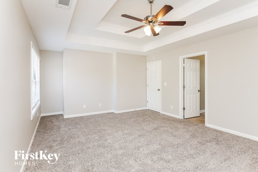 an empty living room with a ceiling fan