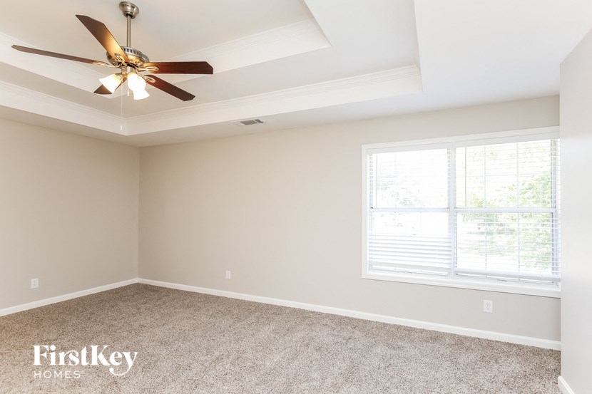 a bedroom with a ceiling fan and a window