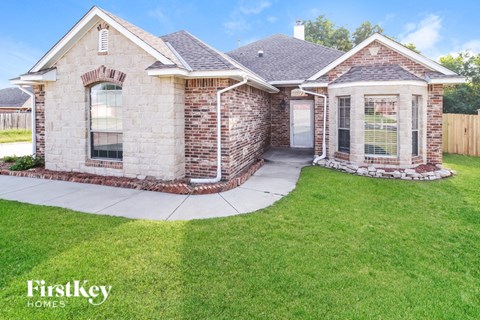 A brick house with a stone pathway leading to the front door.