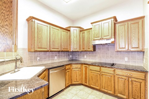 A kitchen with wooden cabinets and a dishwasher.
