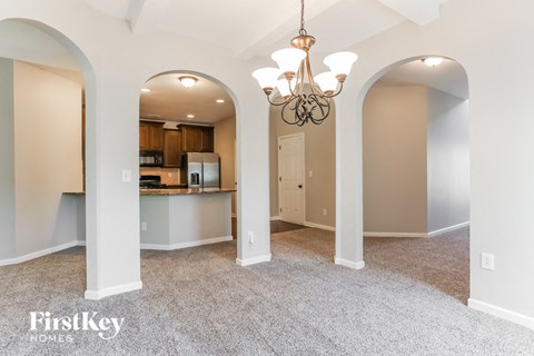 A spacious room with a chandelier and arched doorways.