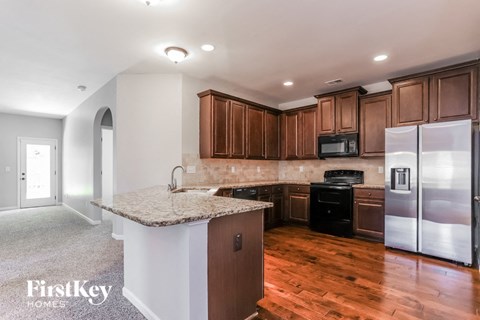 A kitchen with wooden cabinets and a granite countertop.