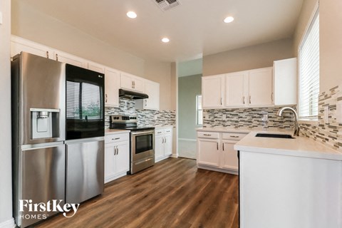 a kitchen with white cabinets and stainless steel appliances