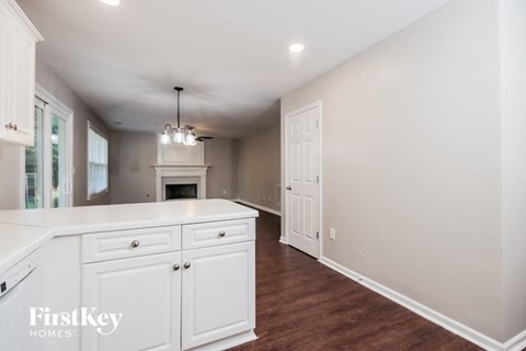a white kitchen with white cabinets and a fireplace