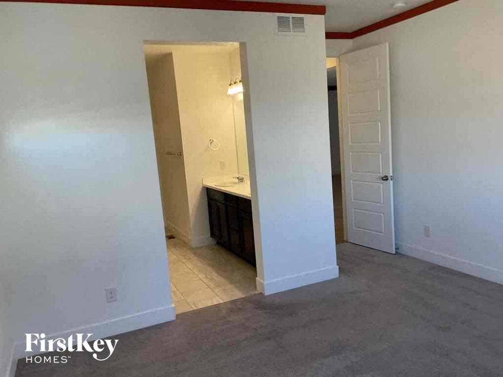 an empty living room with a sink and a door to a bathroom