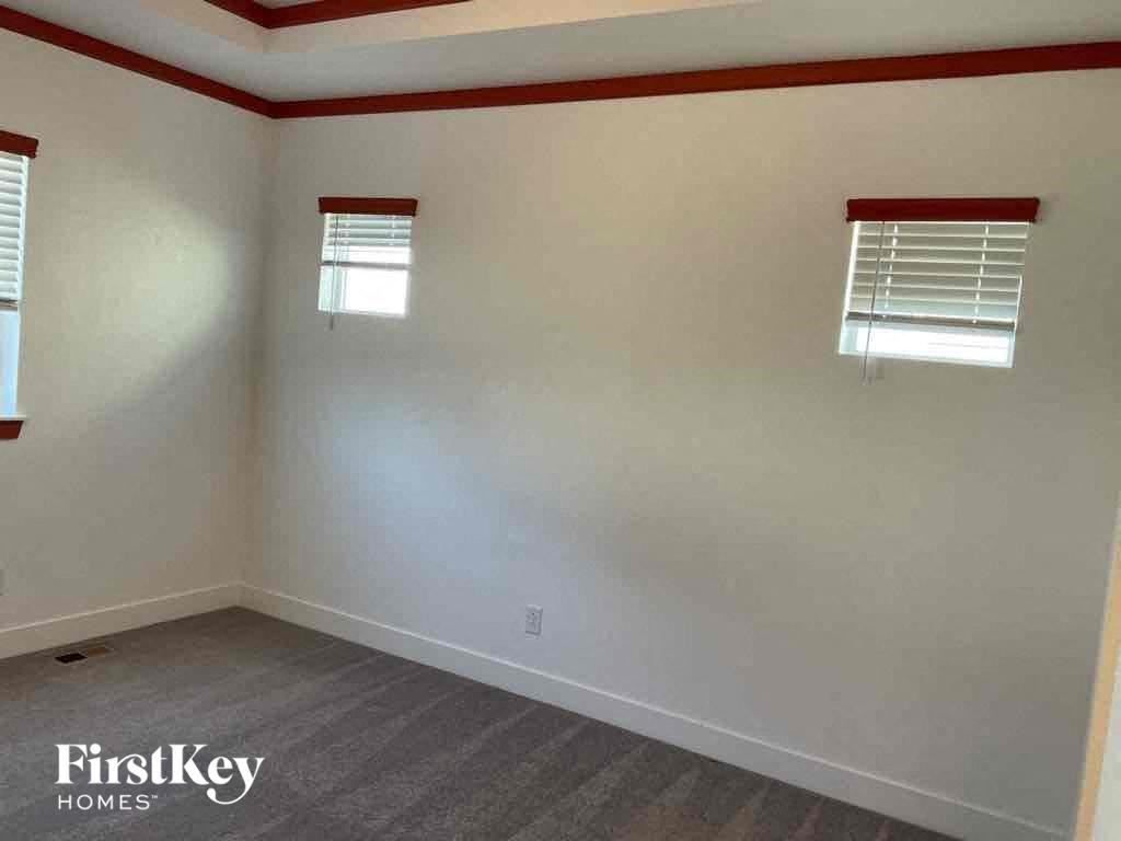 an empty room with white walls and two windows