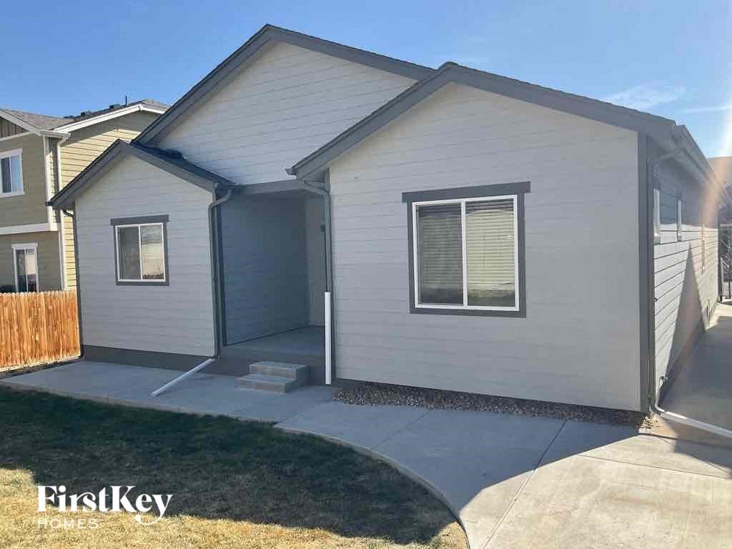 a small white house with a sidewalk in front of it