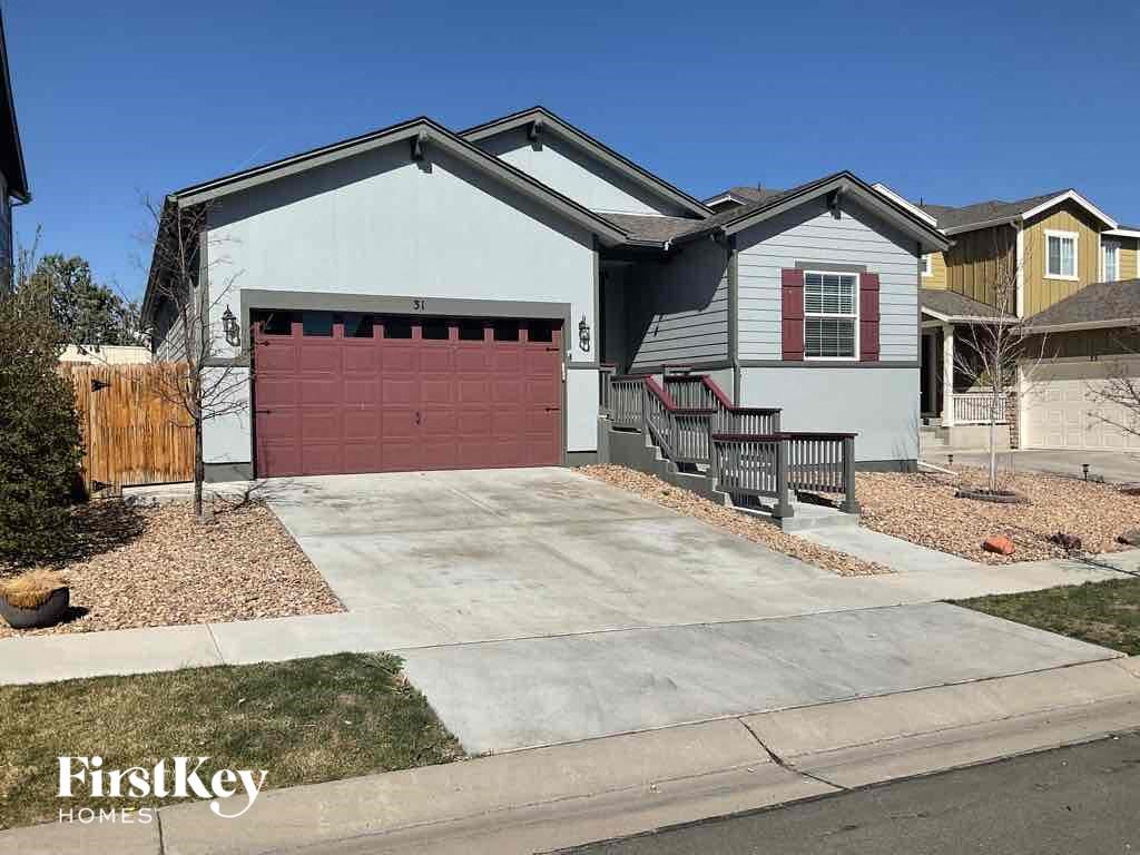 a house with a red garage door in front of a driveway
