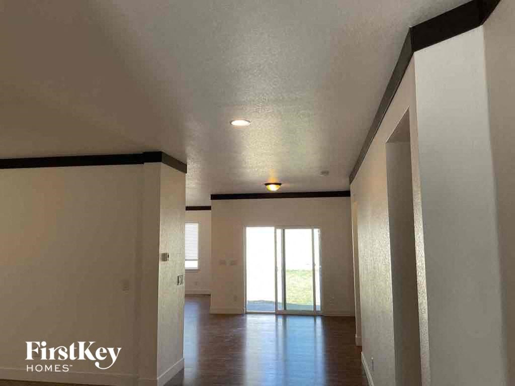 an empty living room with white walls and a glass door