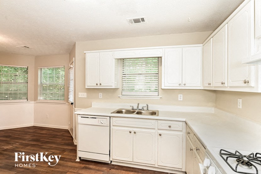 a white kitchen with white cabinets and a sink