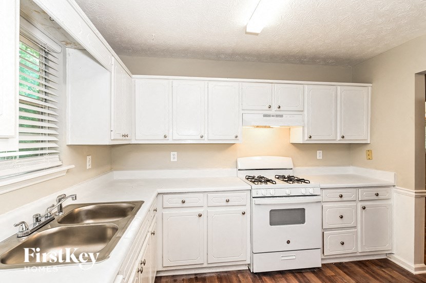 a kitchen with white cabinets and appliances and a sink