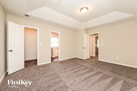 a living room with carpet and a door to a bathroom