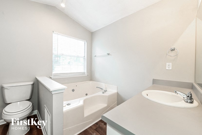 a white bathroom with a tub and a sink and a toilet