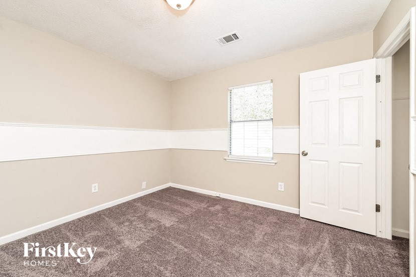 the living room of a home with carpet and a white door
