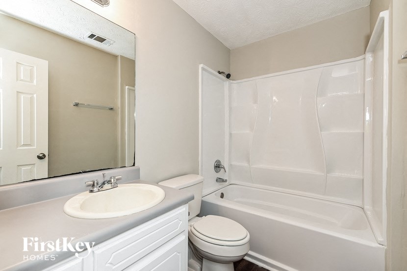 a white bathroom with a sink toilet and tub
