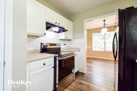a kitchen with white cabinets and a black refrigerator