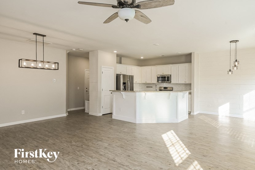 an open kitchen and living room with a ceiling fan