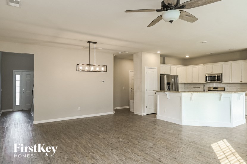 an empty kitchen with white cabinets and a ceiling fan