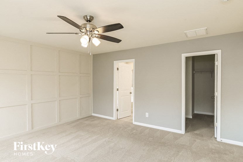 a bedroom with a ceiling fan and a closet