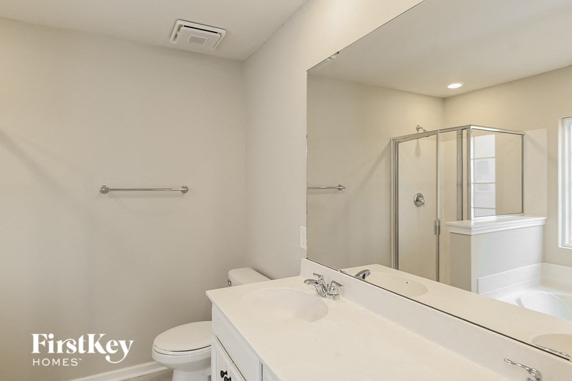 a white bathroom with a toilet sink and a shower