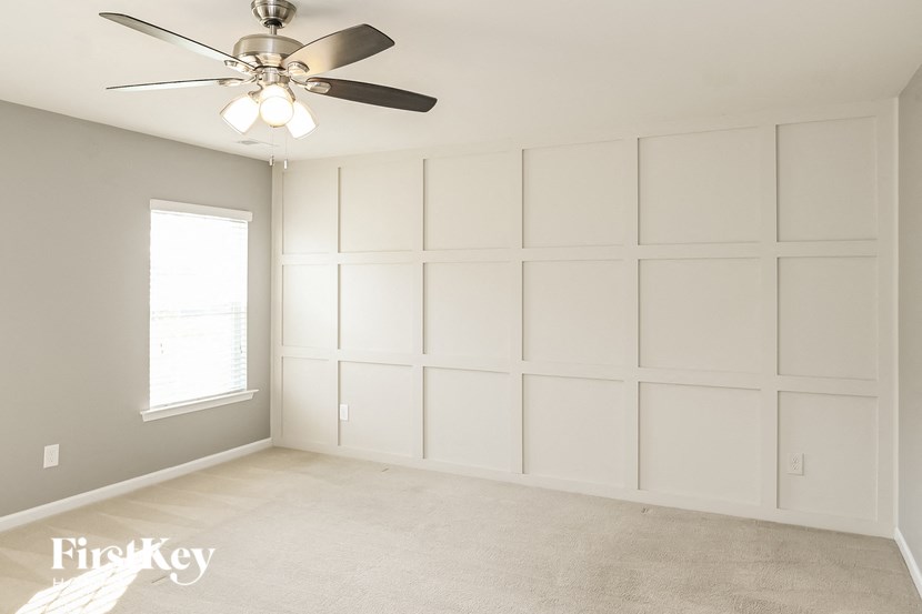 a white room with a ceiling fan and a window