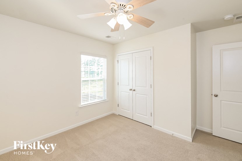 a bedroom with a ceiling fan and a closet