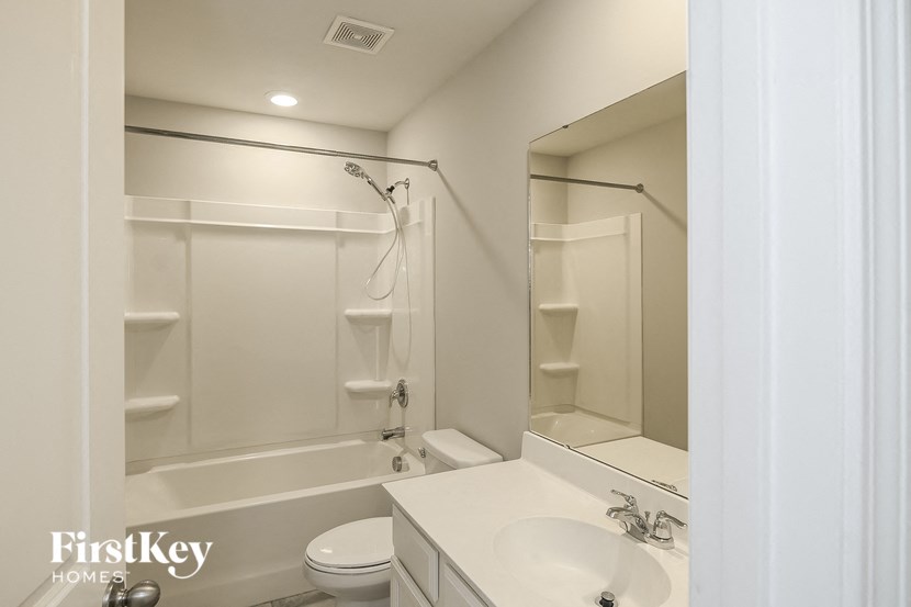 a white bathroom with a shower sink and toilet