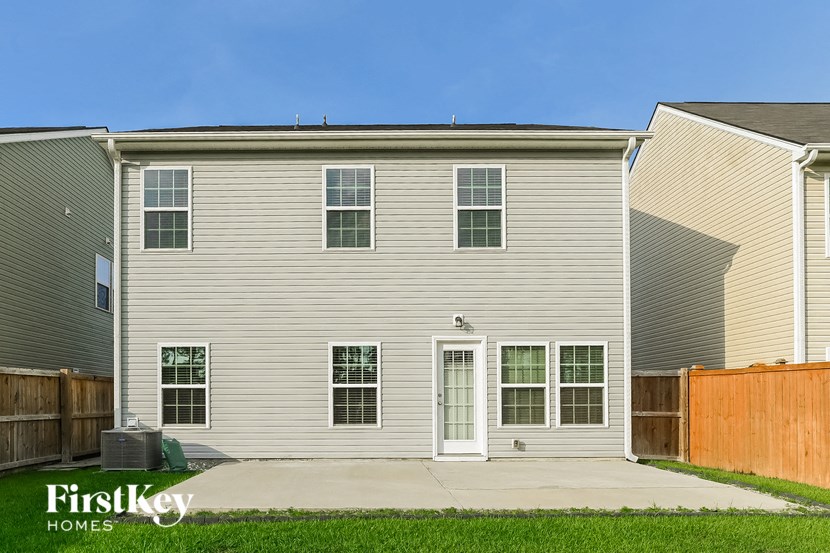 a white house with white siding and a wooden fence