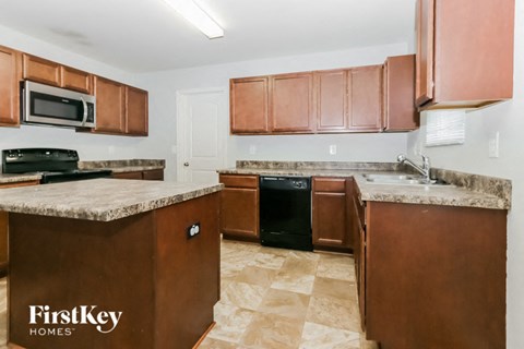 A kitchen with brown cabinets and a black oven.