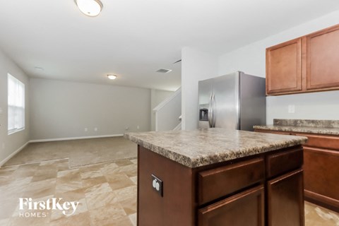 A kitchen with a granite countertop and wooden cabinets.