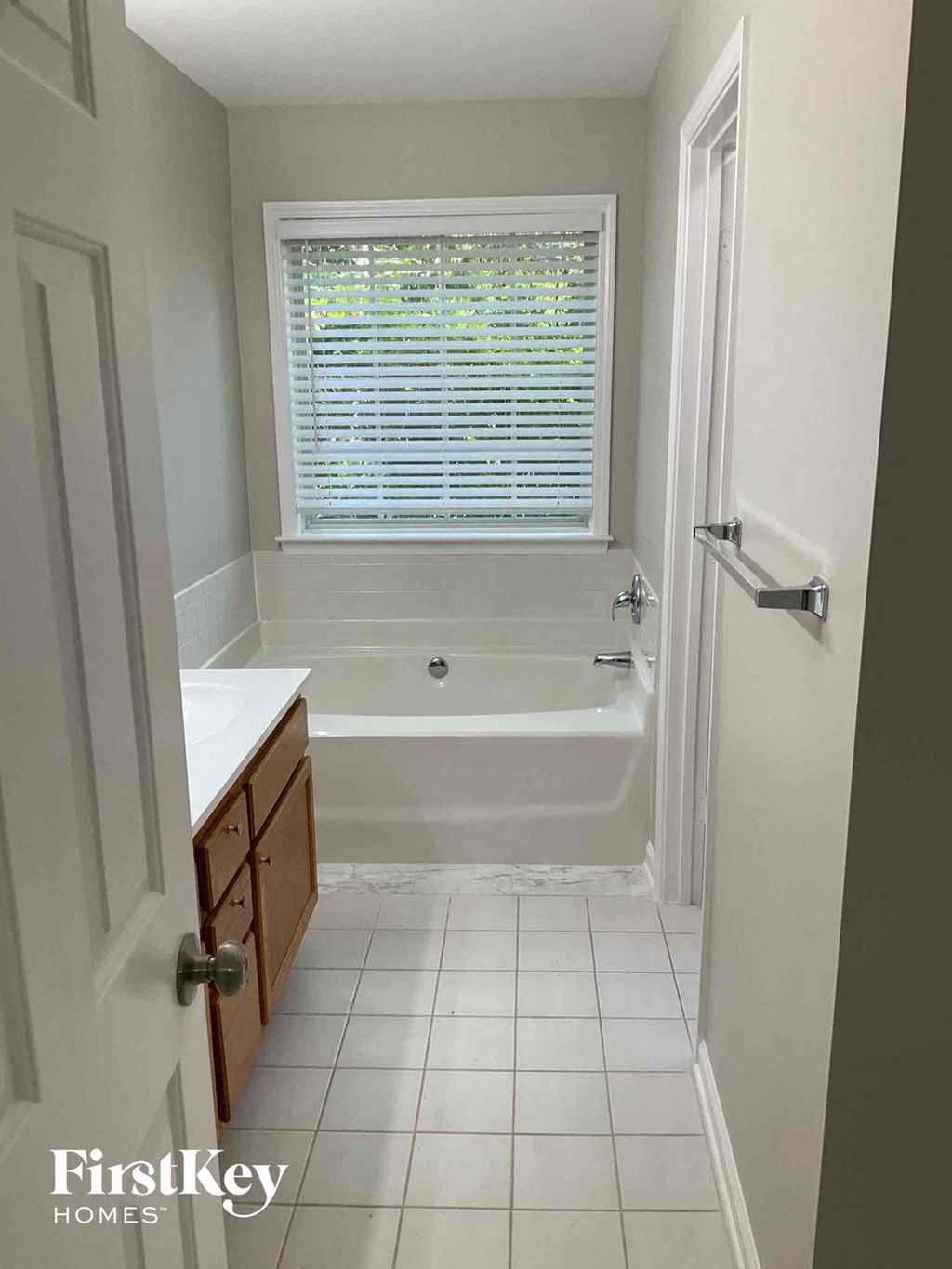 a small bathroom with a tub and a sink and a window