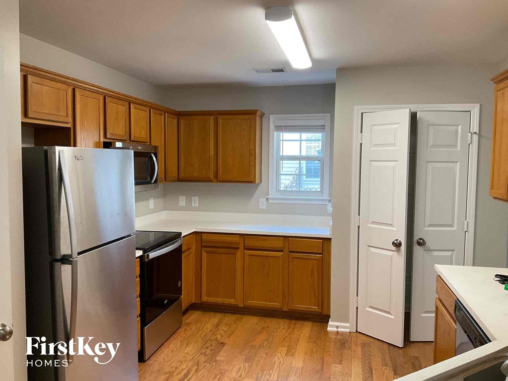 an empty kitchen with wooden cabinets and stainless steel appliances