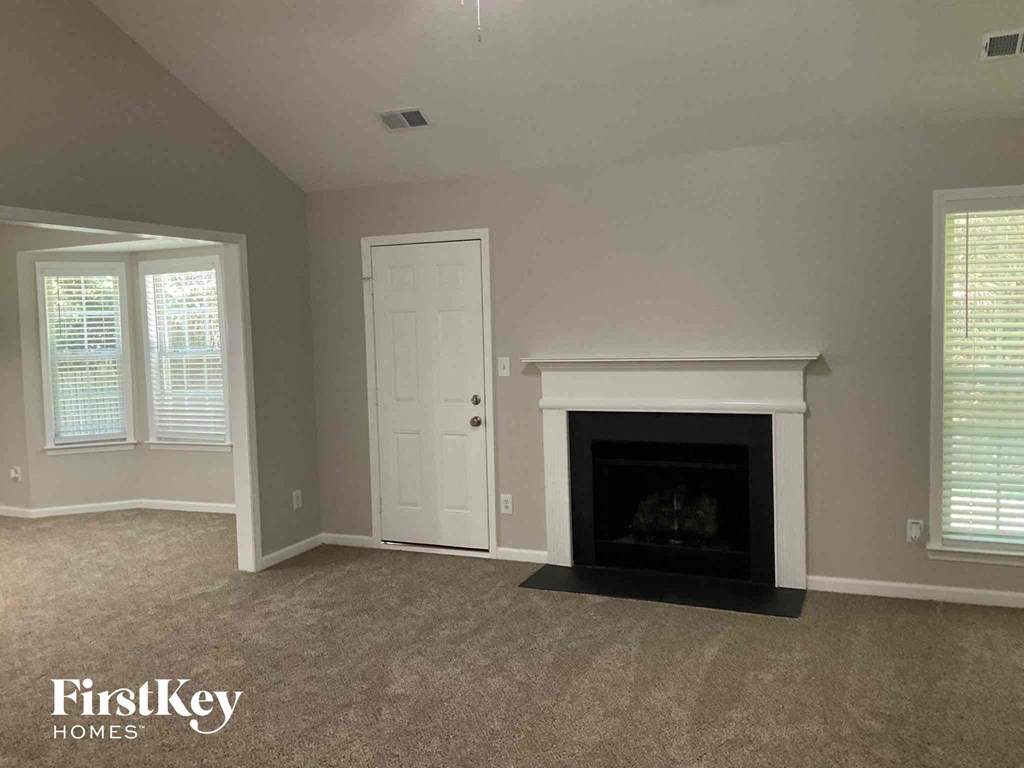 a living room with a fireplace and a white door