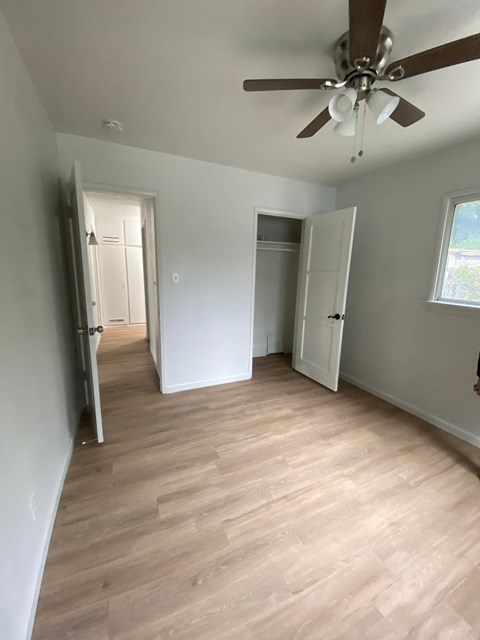 a living room with a wood floor and a ceiling fan